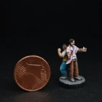 Une figurine du 7ème Continent à côté d’une pièce d’un centime d’euro, Philias Fogg et Jean Passepartout, deux personnages dos à dos, l’un grand, moustachu, habillé d’un costard rose et l’autre, petit et musclé, habillé de jaune.