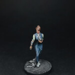 Une figurine de Nemesis, L'Android, personnage féminin vue de face, vêtu de vêtement bleu, un écran fixé au bras droit.