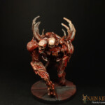 Une figurine de Nemesis, le Boucher, grande créature vue de face, issue d’un mélange de chair humaine, possède quatre pattes musclées, deux crânes et des côtes qui ressortent.