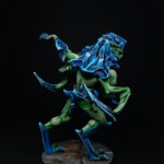 Intru Hybride Une figurine de Nemesis, un Intrus Hybride, créature vue de derrière, bipède, possède deux bras, carapace sur le torse, avant bras et tête de couleur bleue, se tient debout.