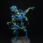 Intru Hybride Une figurine de Nemesis, un Intrus Hybride, créature vue de face, bipède, possède deux bras, carapace sur le torse, avant bras et tête de couleur bleue, se tient debout.