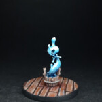 Kami d'eau Une figurine de Okko Chronicles, Kami d’eau, petite créature faite d’eau aux formes arrondies et qui se tient dans un seau.