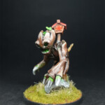 Kami de terre Une figurine de Okko Chronicles, Kami de terre de face, créature fait de bois sur un caillou doté d’une cabane à oiseaux sur le dos.