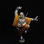 Oni-Sorio Une figurine d’Okko Chronicles, Oni-Sorio, personnage démoniaque vue de face, vêtue d’un kimono orangé avec un sourire maléfique.