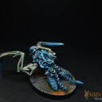 Intrus Rôdeur Une figurine de Nemesis, un Intrus Rôdeur, créature vue de derrière, possède deux bras crochus, n’a pas de membres inférieurs, carapace sur le torse, avant bras et tête de couleur bleue, rampe.
