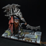 Une figurine de Brutality, The God Killer avec son épée et son grand bouclier vue de derrière