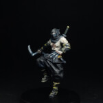 Tigre noir Une figurine de Okko Chronicles, Tigre noir, un ninja visage caché et torse nu, équipé d’un tekko-kagi et d’un kuragisama.