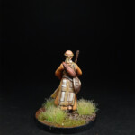 Tikku Une figurine de Okko Chronicles, Tikku de derrièreavec son bâton dans une prairie.