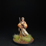 Tikku Une figurine de Okko Chronicless, Tikku de face avec son bâton dans une prairie.