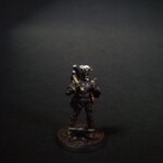 Front view of a D&D character Personnage à la couleur noire ébène, il tient un marteau dans une main et se tient devant une enclume